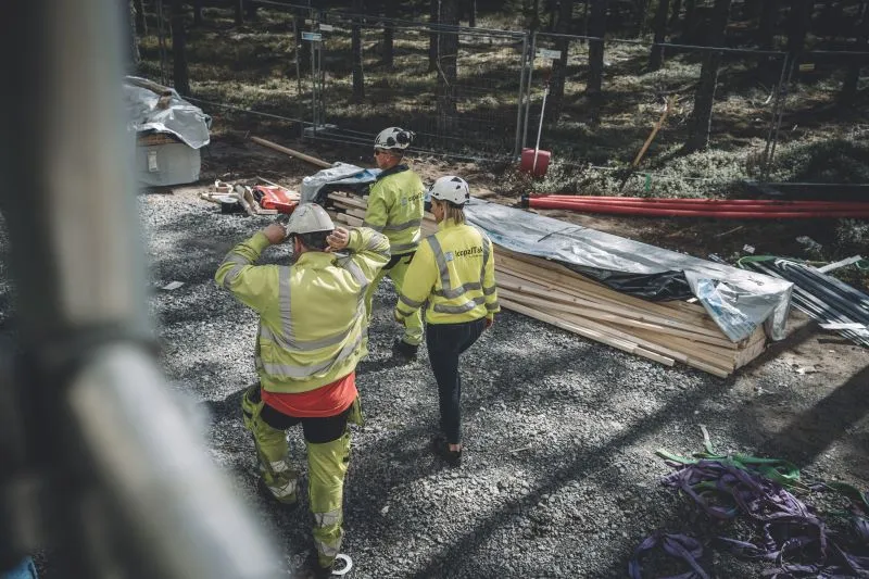 Taktekkere på arbeidsplass med hjelm og arbeidsklær på